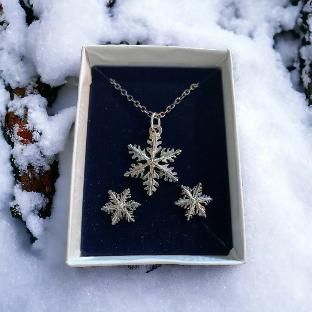 Boxed set of silver tone snowflake earrings and pendant
